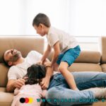 Kinder tollen auf Vater herum